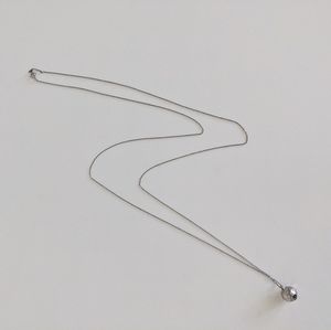 Long silver necklace with ball pendant